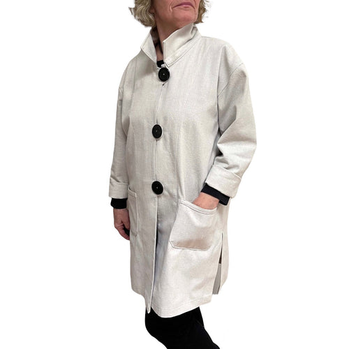 Person wearing a white coat with black buttons on a white background