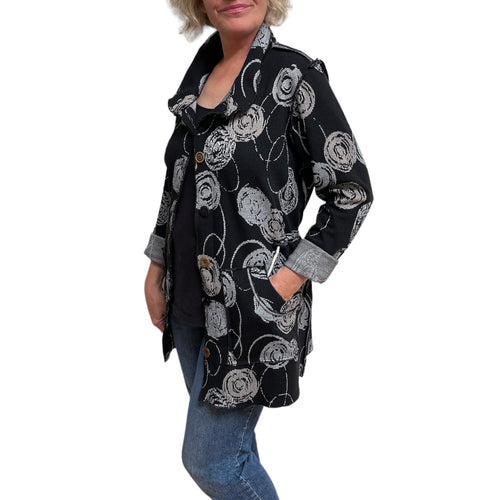 Person wearing a black floral patterned coat on a white background