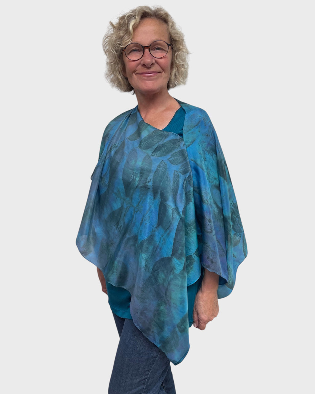 Turquoise black walnut eco print silk poncho worn open at V-neck, three quarter front view