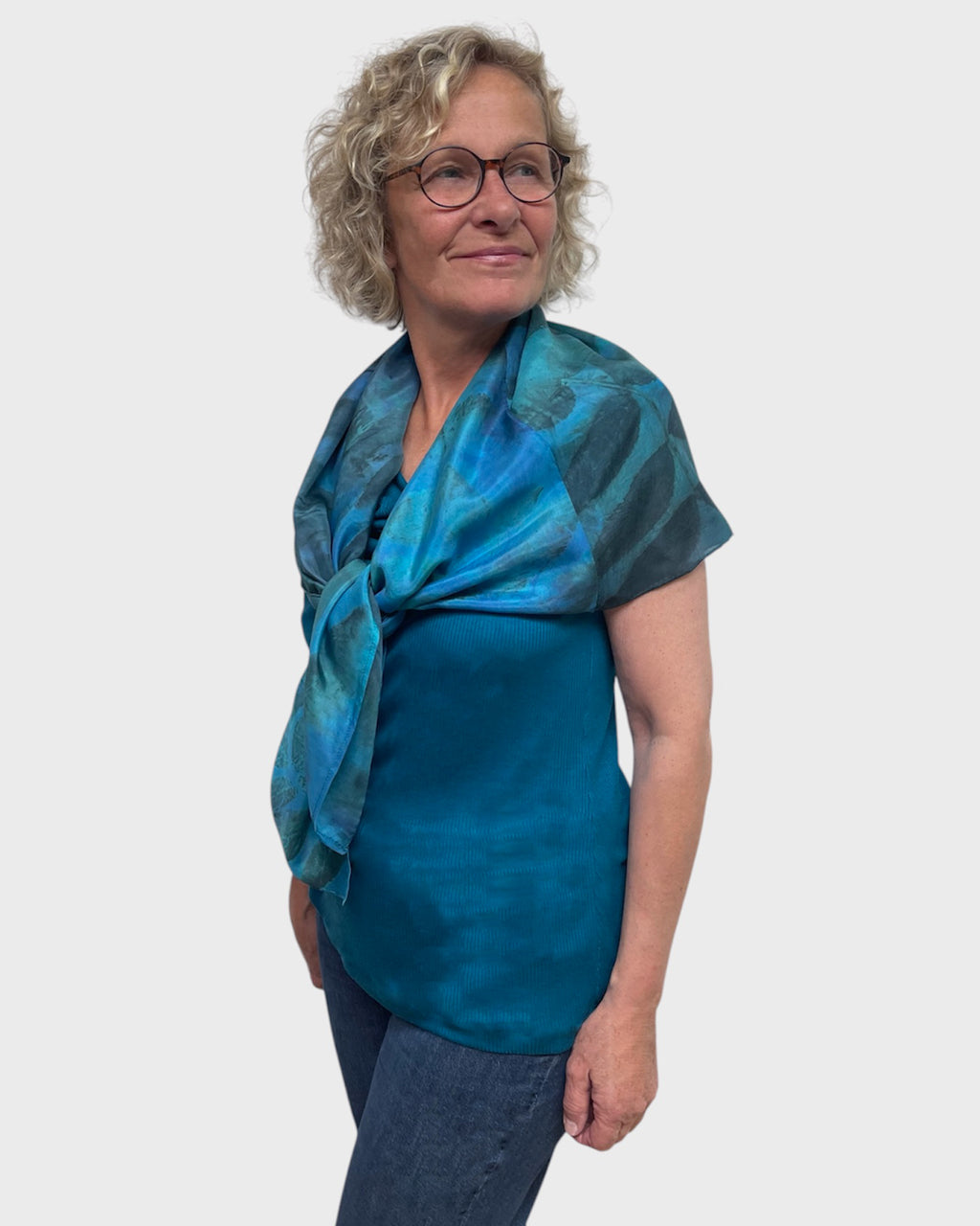 Turquoise silk poncho tied loosely at the shoulder like a statement scarf, black walnut print