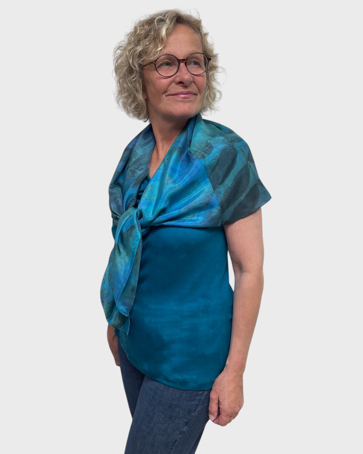Turquoise silk poncho tied loosely at the shoulder like a statement scarf, black walnut print