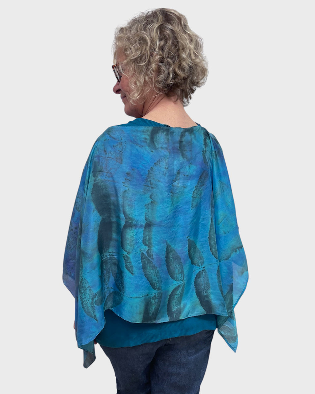 Back view of turquoise black walnut eco print silk poncho showing matching print on reverse side