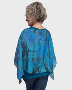 Back view of turquoise black walnut eco print silk poncho showing matching print on reverse side