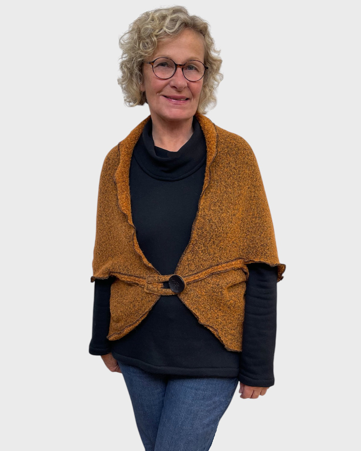 Pumpkin and black wool polyester shrug closed with one large button over a black cowl neck top