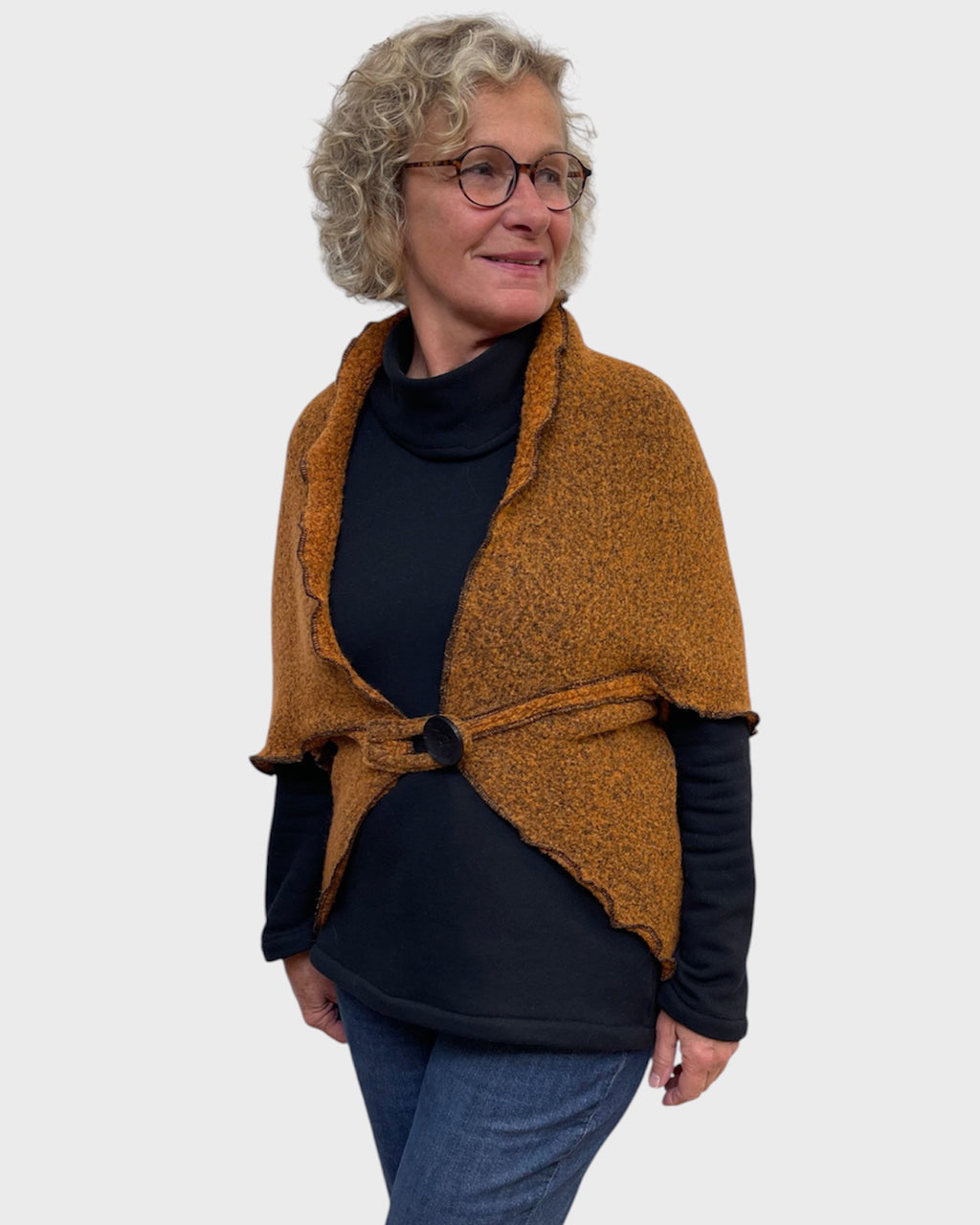 Side view of pumpkin and black wool polyester shrug closed with one button